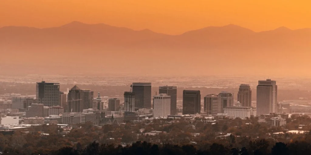 Modern cityscape with mountain horizon during sunset
