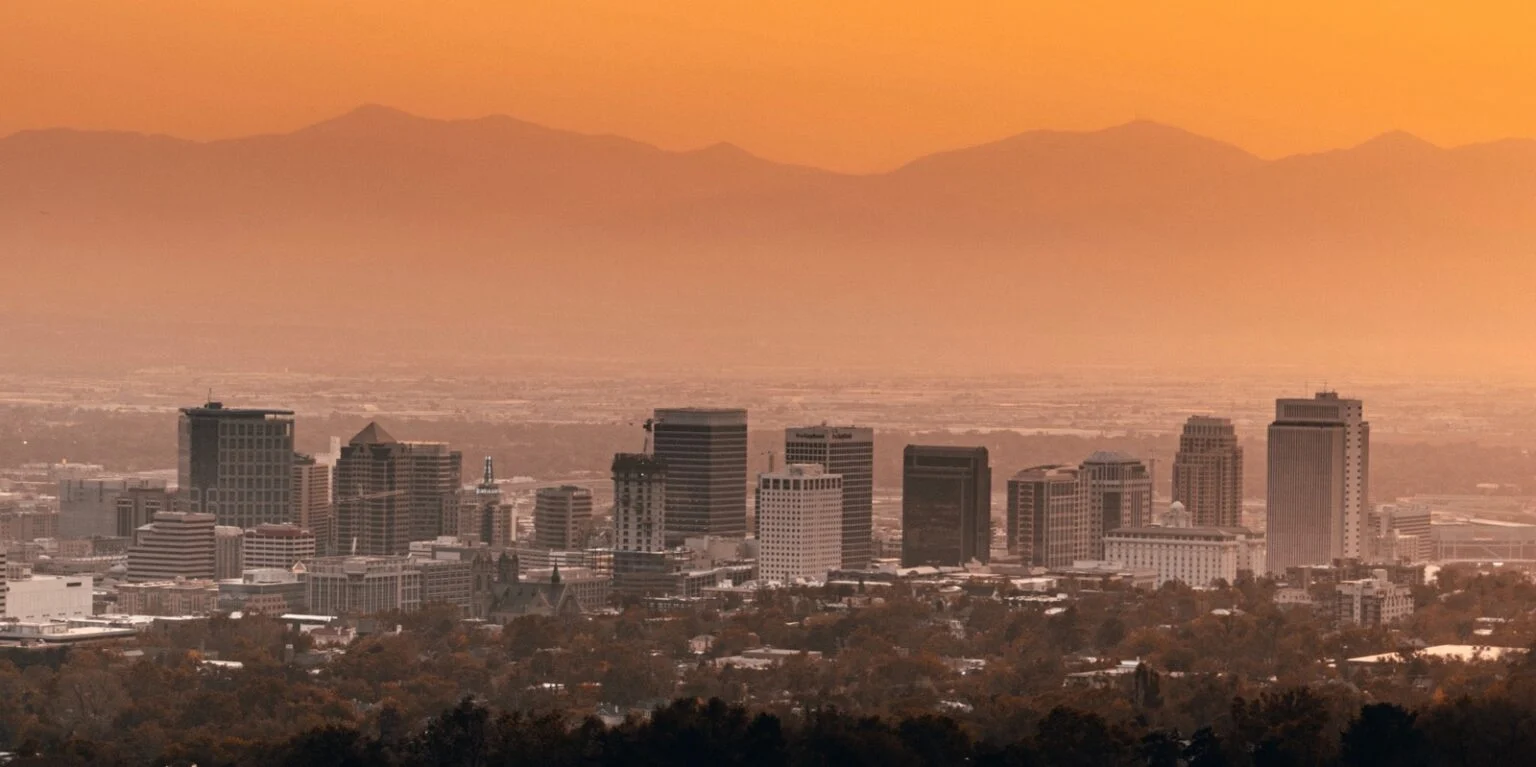 Modern cityscape with mountain horizon during sunset